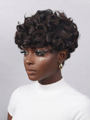 A woman wearing a short, voluminous dark brown curly wig, styled with glittery eye makeup and a white ribbed turtleneck top against a light gray background.